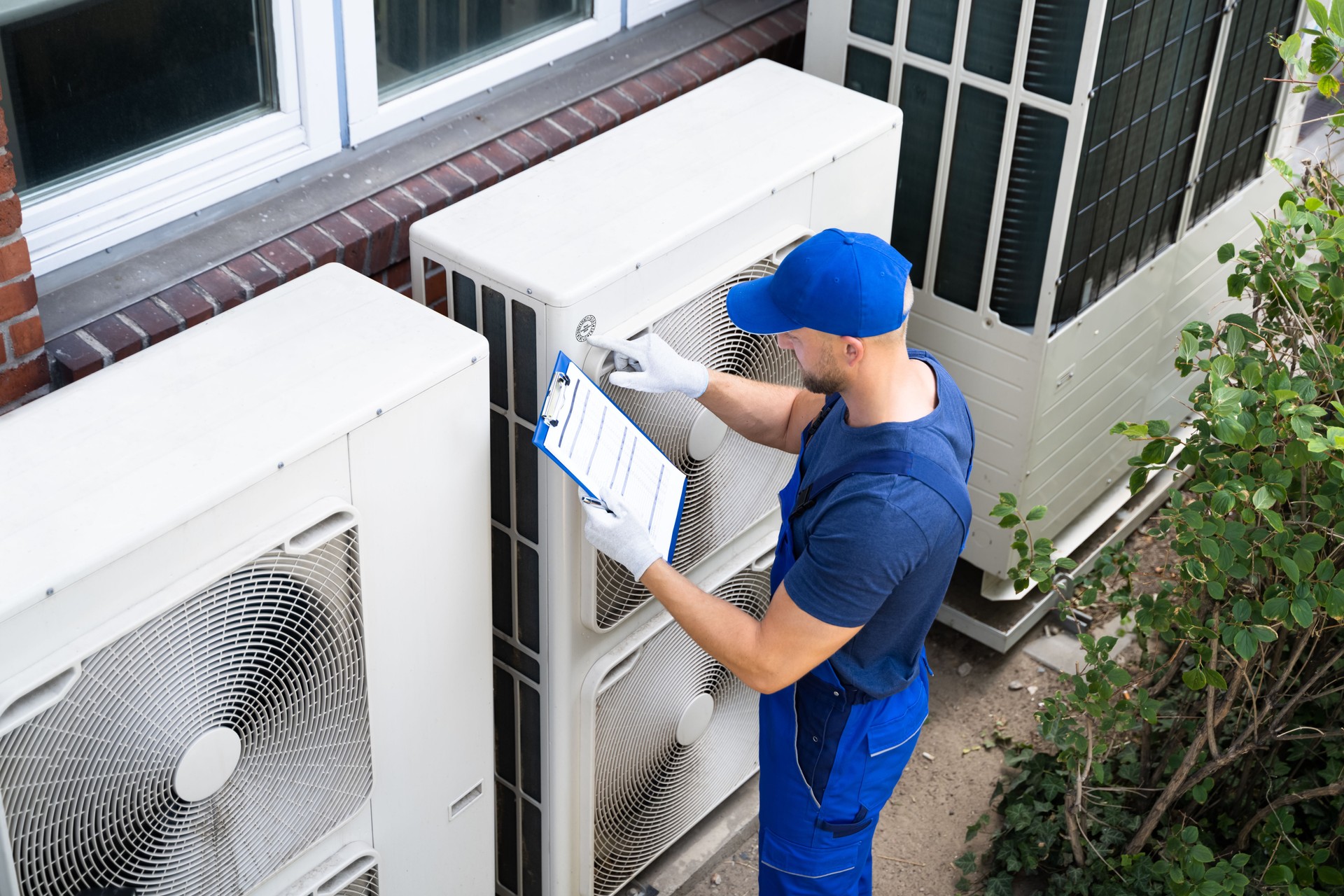 An Electrician Men Checking Air Conditioning Unit